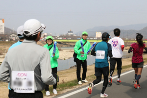 Corporate volunteers cheering runners
